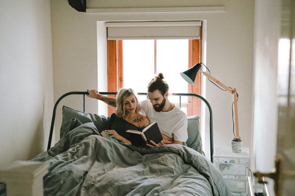 a photo of a couple reading an experience-based relationship book