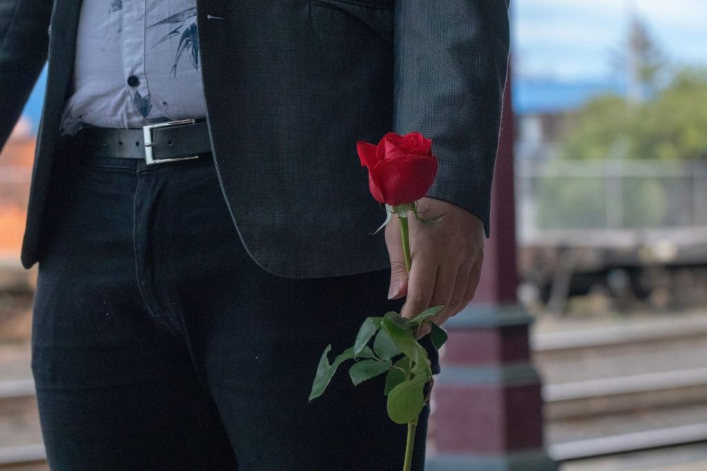 a photo of a man holding a rose one of the things men need to commit in relationships